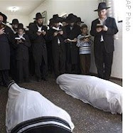 Mourners pray over bodies of Rabbi Gavriel Noach Holtzberg and his wife,