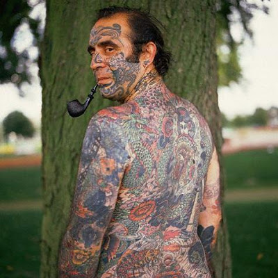 A man whose body and face full of Japanese tattoo, and the big dragon,