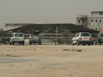 Cars wait outside a sacrificial tent in Umm Slal Mohammed, Qatar.