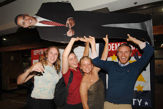 U.S. study abroad students, from left, Amanda Lawrence, 20, from Detroit, Michigan, Caitlain Kelly, 22, from San Francisco, California, Anna Rohde, 21, from South Dakota, Benjamin Weidman, 22, from New York, hold up a life-size poster of President-elect Barack Obama while celebrating in western San Jose. (Photo: Lindy Drew/Tico Times)