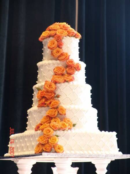 Stunning four tier round textured white wedding cake with a cluster of 