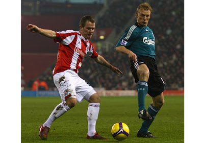 Glenn Whelan of Stoke City competes for the ball with Dirk Kuyt of Liverpool