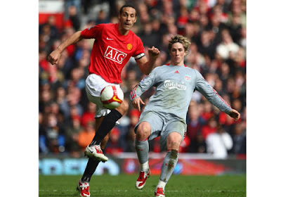 Rio Ferdinand of Manchester United battles for the ball with Fernando Torres of Liverpool