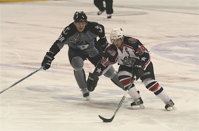 Credit:Jane Rickard,Wolves Captain #20 Haydar and Janne Niskala fly tward Pekka Renne and the Milwaukee net.