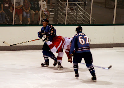 Credit: Jane Rickard, Chad Denny and Aaron Alphondo taking a unidentified Detroit player out of play.