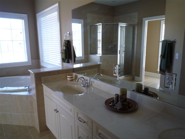 Master Bath with two sinks and large windows over-looking Back Yard and Outdoor Patio