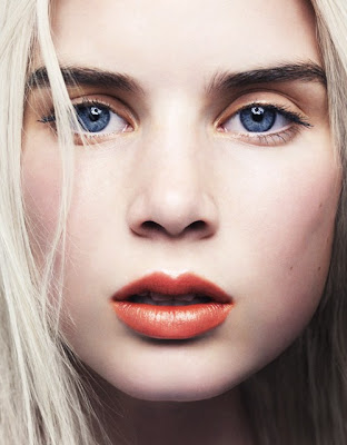 Blue eyes, blond hair, dark, thick eyebrows, pale skin and red-orangy lips.