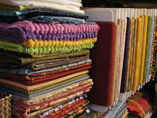 Some of my fabric stash: folded and stacked as well as wrapped around foam core boards.