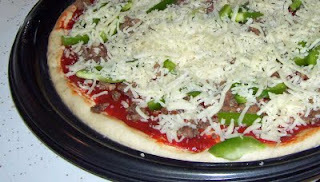 One pan of pizza assembled and ready for baking.
