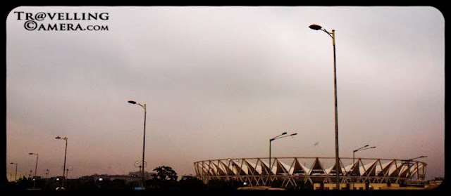 Dilli Bhraman in Monsoons to check out the state of the city before CWG 2010 (Common Wealth Games) : Posted by VJ SHARMA @ www.travellingcamera.com : On a weekend, we were discussing overall progress of Delhi in last few months for Common Wealth Games.. and there were many debates happening on dinner table.. After some time we decided to have a round of Delhi next day to see what all is happening... Here are few photographs with some brief details about this journey which started from Noida...Yellow-&-Green Auto-Rikshaws are identity of Delhi and first attempt was to find an auto at reasonable cost for a day, which is very difficult task in Noida.. We hired one till Mayur Vihar Phase-1 to catch another friend there... After leaving Noida, we saw a fly-over where construction was going on and most of us thought that its impossible to complete it before CWG.. Lets see what happens...One of the Stadium near Safdarjung Tomb in Delhi...Its probably Jawaharlal Nehru Stadium... Just found another photograph of this stadium with nice details @ http://www.prlog.org/10899688-jawaharlal-nehru-stadium-features-tensile-membrane-fabric-roof-from-birdair-inc.html Green Delhi... I love all the drives around India Gate and CP.. These areas are comparatively green and clean... As you must have noticed that suddenly the main idea disappeared after some time.. I mean, after lunch no one was interested in exploring CWG progress... Here is a photograph of DND which connects Delhi with Noida... Its not allowed to stop the car on DND, so its clicked from moving car having tinted glasses :-) Another photograph of Wide roads of Delhi with sufficient greenery around...Some decorative stuff planted in the center of INA flyovers... Check out http://en.wikipedia.org/wiki/2010_Commonwealth_Games for more details about CWG 2010