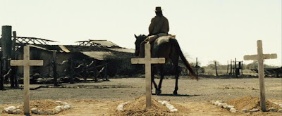 Desolation: physical and moral. Charlie rides past three graves and a ruined house.