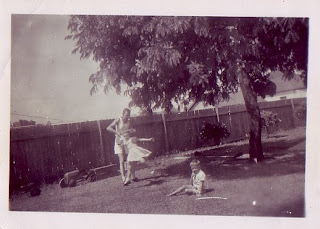 Dad giving me twirls. Along the fence, the prize exhibit: Dad constructed a dinky and cart for us of pieces he found on the tip. Useful bloke to have around.