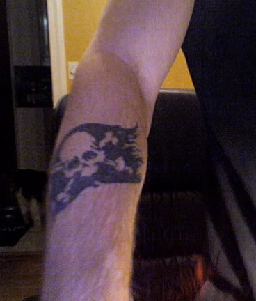 Pirate flag tattoo on forearm.