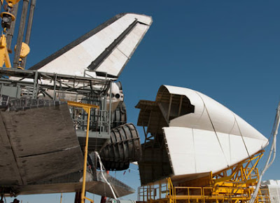 Technicians attach a cover over Discovery's engines Technicians attach a cover over Discovery's engines