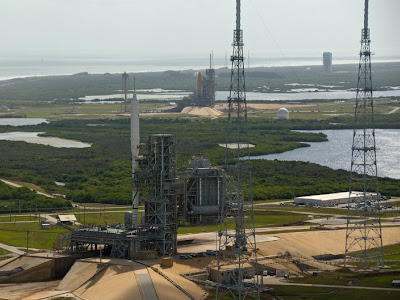 The Ares I-X flight test vehicle and space shuttle Atlantis sit on adjoining launch pads The Ares I-X flight test vehicle and space shuttle Atlantis sit on adjoining launch pads
