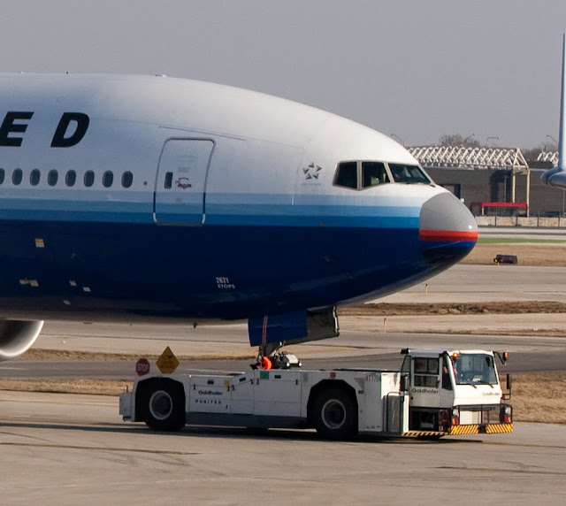 a large airplane with a tow truck on the ground