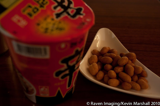 a bowl of peanuts and a container of noodles