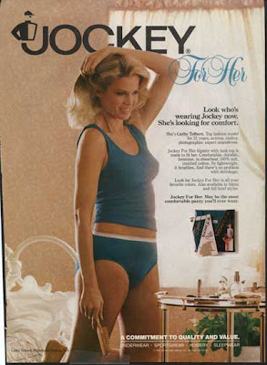 Woman in blue jockey underwear, standing in her bedroom