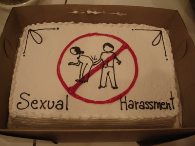 White cake with black drawing of a man slapping a woman's behind, with a red circle and slash over it. The words Sexual Harassment are at the bottom of the cake