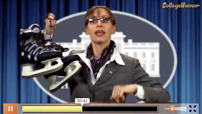 Sarah Palin character in movie trailer holding up a pair of hockey skates at a podium