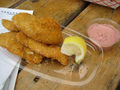 Pieces of breaded and fried fish with lemon and pink dipping sauce