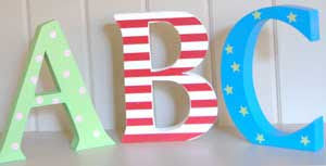 Brightly painted wooden ABC letters on a shelf