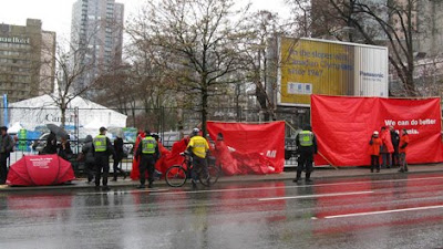 Red tent campaigners seek Guinness World Record, Housing activists wrapped red banners around the Canada Pavilion in Vancouver Saturday to raise awareness of national housing issues, Red tent picture, Red tent photo, Red tent image, Red tent video.