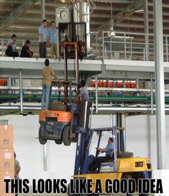 photo of 2 a forklift lifting another forklift