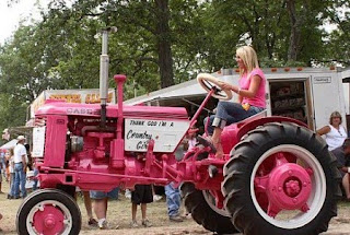 Эксплуатация машинно-тракторного парка. Деревенская девушка в розовой кофточке на розовом тракторе.