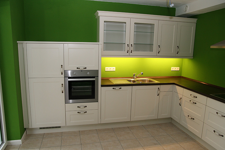 Küche mit grünen Holzfronten und grau grüner Wand