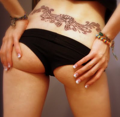 A blue rose tribal tattoo at girl's lower back.