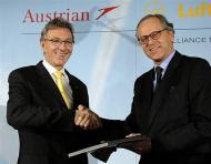 CEO of Austrian state holding company OeIAG Peter Michaelis (R) shakes hands with Wolfgang Mayrhuber, CEO of Lufthansa - AFP photo Austian Airlines-Lufthansa