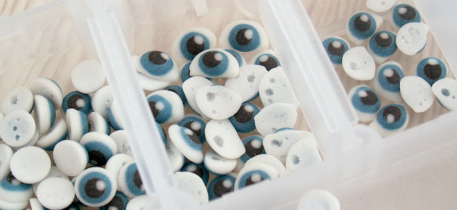 Close up of royal icing eyes for decorating character cookies, dried and sorted for size, by Honeycat Cookies