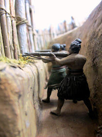 Diorama of Maori with muskets in a trench, defending a pa.
