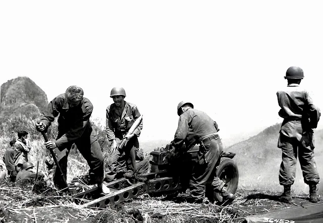 US Army soldiers firing artillery at cave in Lipa, Batangas in 1945.  Image source:  United States National Archives.