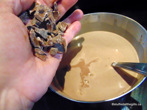 Pouring a handful of left-over chocolate into a pot of hot chocolate.