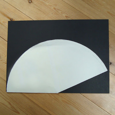 A template for a witches hat placed on A3 black card.