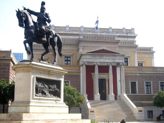 Το άγαλμα του Κολοκοτρώνη στην Αθήνα, φιλοτέχνημα του Σώχου. Στην βάση του φαίνεται ένα από τα δύο ανάγλυφα. Κατασκευάστηκε το 1900 στο Παρίσι και στήθηκε το 1904 στην Αθήνα.