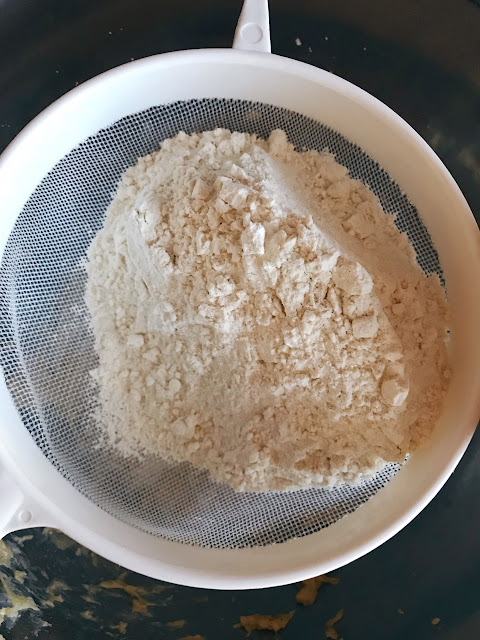 Flour being sieved into the mixture