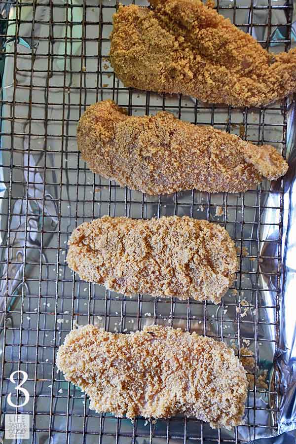Breaded chicken breasts on a rack in a baking tray ready to go in the air fryer