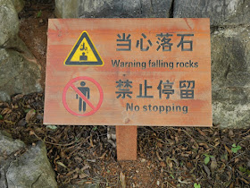 sign with "Warning falling rocks" and "No stopping"