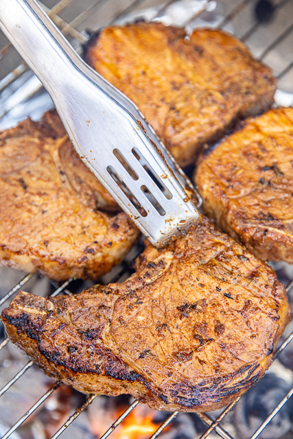 Grilled Blackened Pork Chops - the BEST pork chops EVER! SO much amazing flavor! Pork chops are marinated overnight in a mixture of garlic, onion, thyme, oregano, paprika, tarragon, salt, red pepper, black pepper, olive oil and Worcestershire sauce. Throw on the grill for about 10 minutes when ready to eat! SO easy and delicious! Don't miss this one! #pork #porkchops #grilling #cajun pork chops on the grill