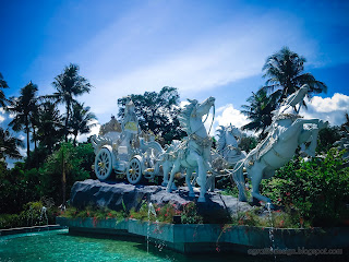 Krishna's Chariot Statue In The Middle Of A Garden Pond On A Sunny Day At Tangguwisia Village, North Bali, Indonesia