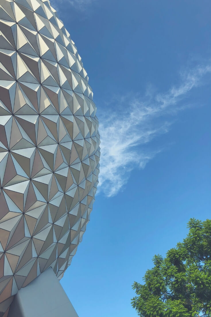 Spaceship Earth in Epcot, Walt Disney World, against a blue sky with a misty white cloud.