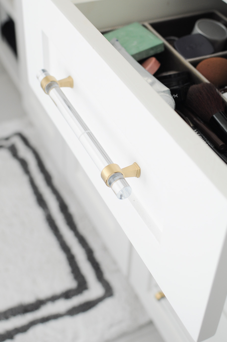 These gold or brass lucite pulls look fabulous against the white shaker cabinets in this master bathroom suite.