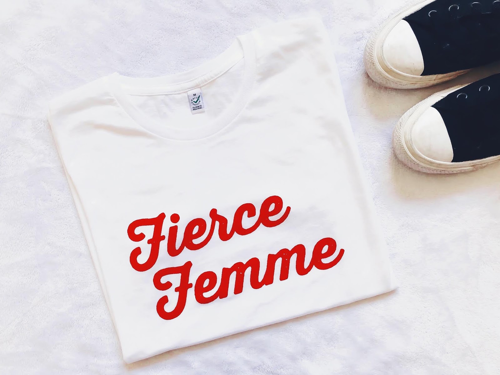 white tshirt with red text that reads fierce femme alongside converse shoes