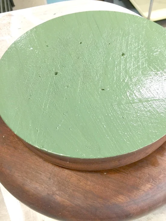 a wooden lazy susan with a painted green bottom