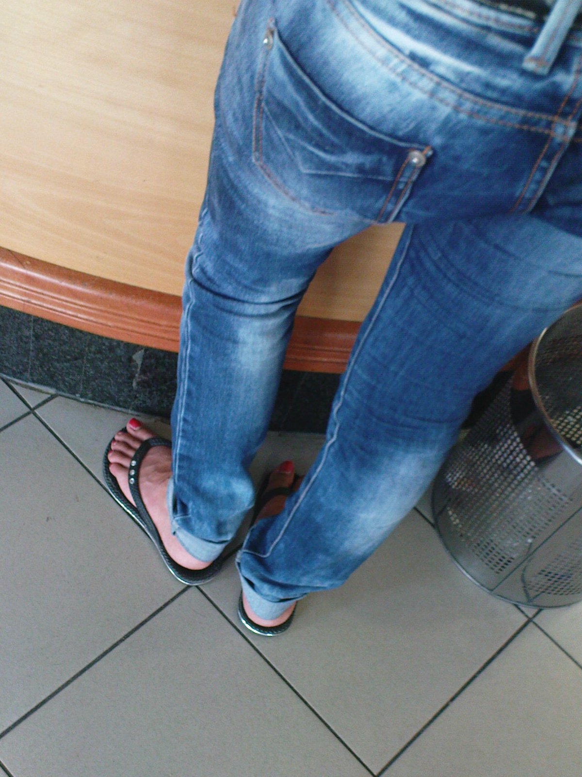 Legs And Feet On The Street Jeans And Flip Flops By The