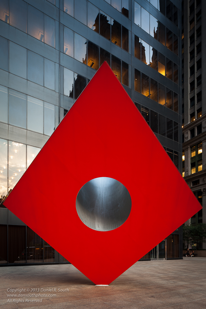 a photo of the red cube metal sculpture in downtown new york