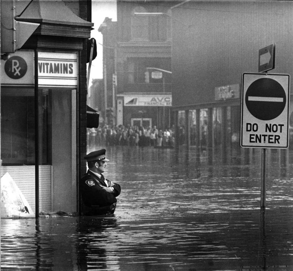 40 Amazing Historical Pictures - Police officer guarding a pharmacy in high-flood waters, Ontario, 1974
